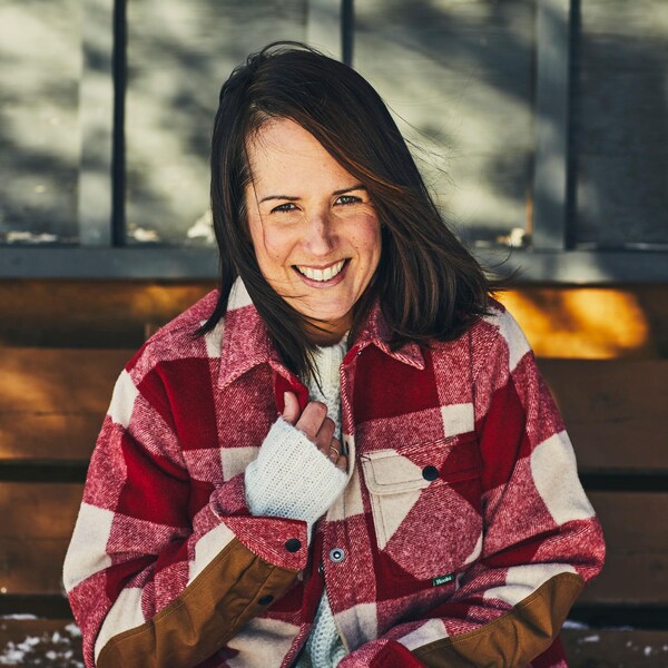 La nutritionniste Geneviève O’Gleman assise sur un banc de bois dehors avec une veste à carreaux.