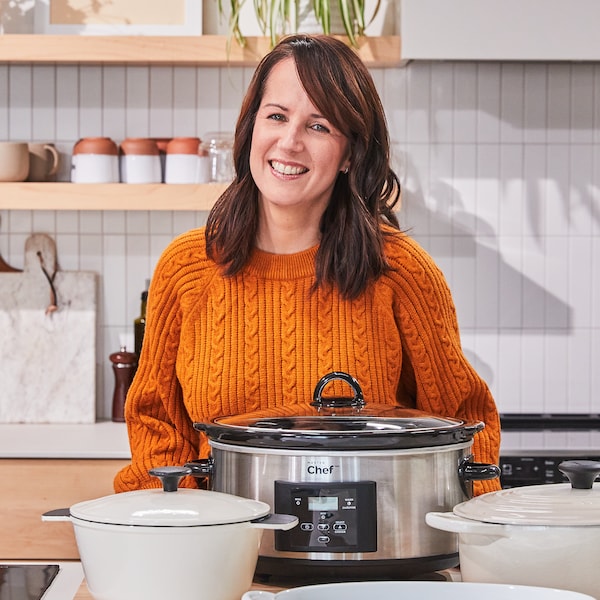 La nutritionniste Geneviève O'Gleman se tient debout dans une cuisine avec une mijoteuse sur le comptoir devant elle. 