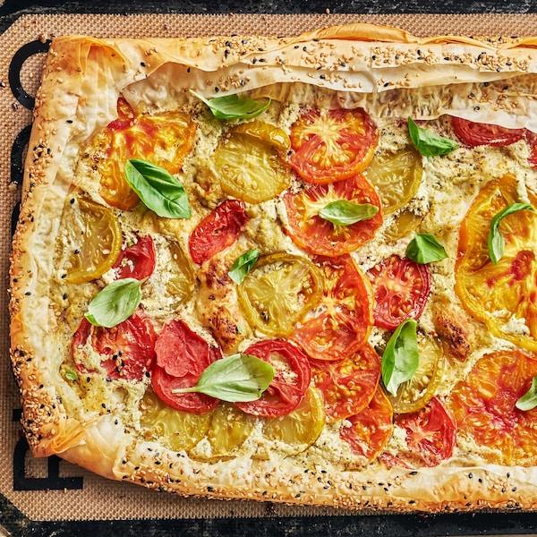 Une tarte aux tomates sur une plaque sortant du four.
