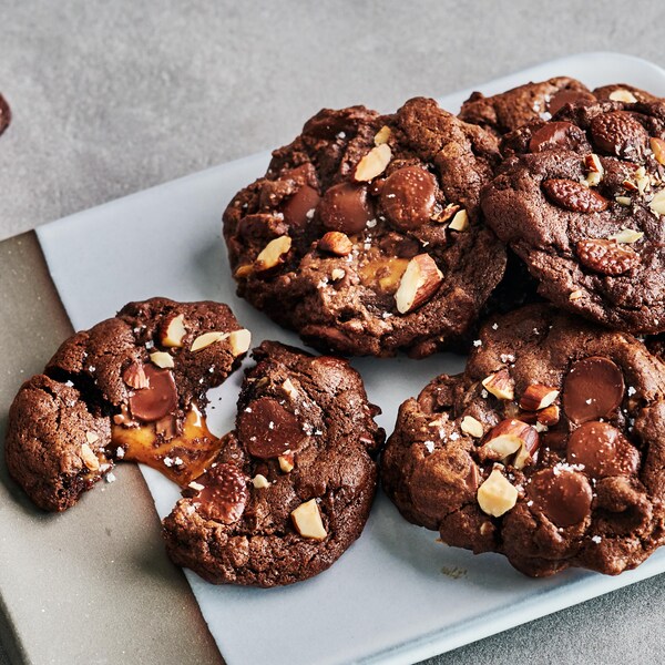 Plusieurs biscuits au chocolat, aux amandes et au caramel dans une assiette.