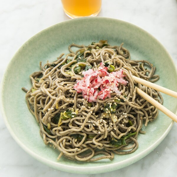 Bol de nouilles soba aux oignons verts avec des baguettes.