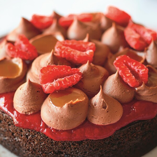 Un gâteau au chocolat décoré de framboises.