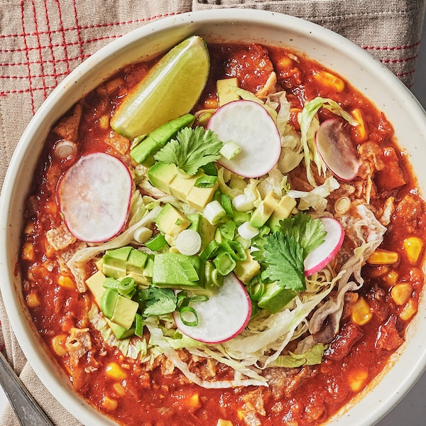 Un bol de soupe pozole mexicaine, garnie de légumes et de lime.