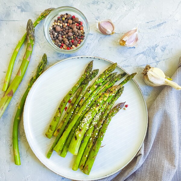Des asperges grillées au sésame dans une assiette.
