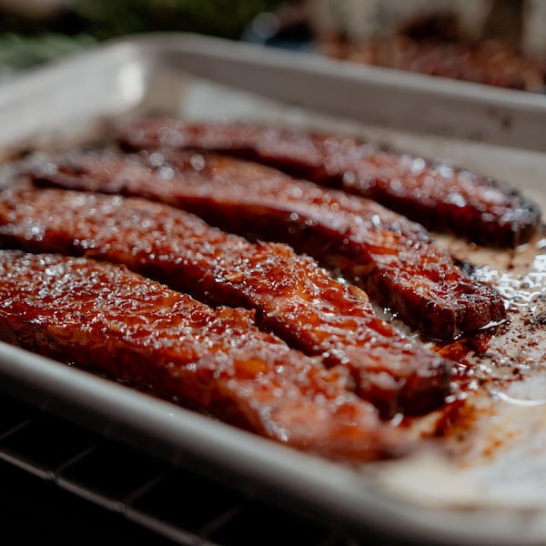 Quatre tranches de bacon laqué à l'érable sortant du four.
