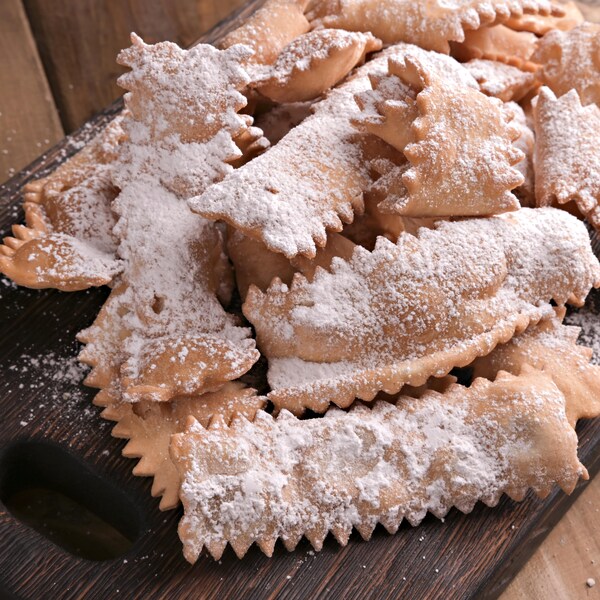 Des beignets en forme de ruban sur une planche à découper.