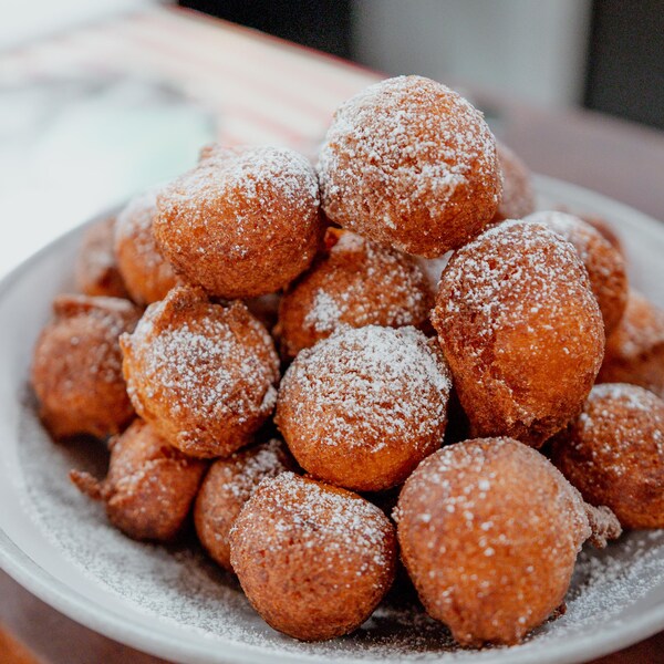 Des beignets à la patate douce dans un bol, saupoudré de sucre blanc. 