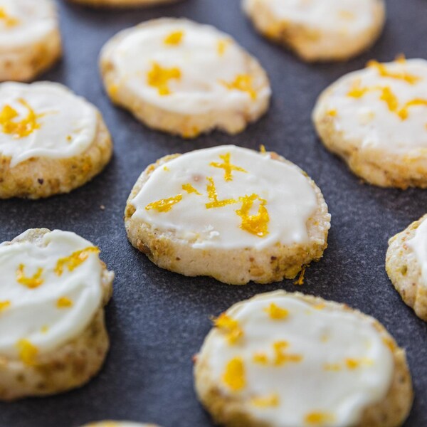 Des biscuits glacés à l’orange et aux pistaches sur un comptoir.