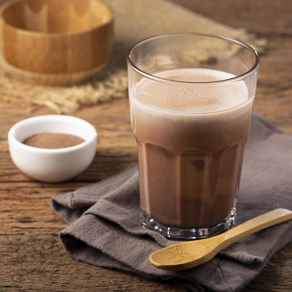 Un verre de boisson végétale au chocolat sur un comptoir.