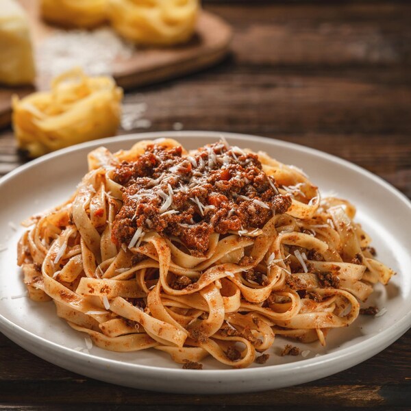 Une assiette de pâtes recouvertes de sauce bolognaise.