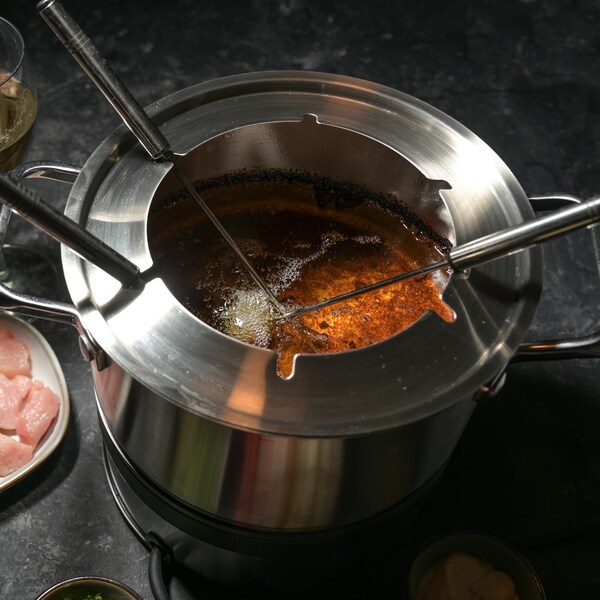 Du bouillon à fondue dans un caquelon à fondue.
