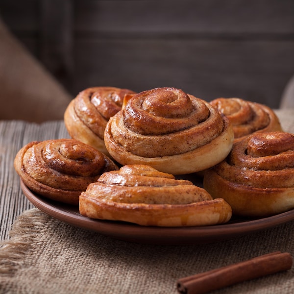 Des brioches roulées à la cannelle et aux raisins dans une assiette.
