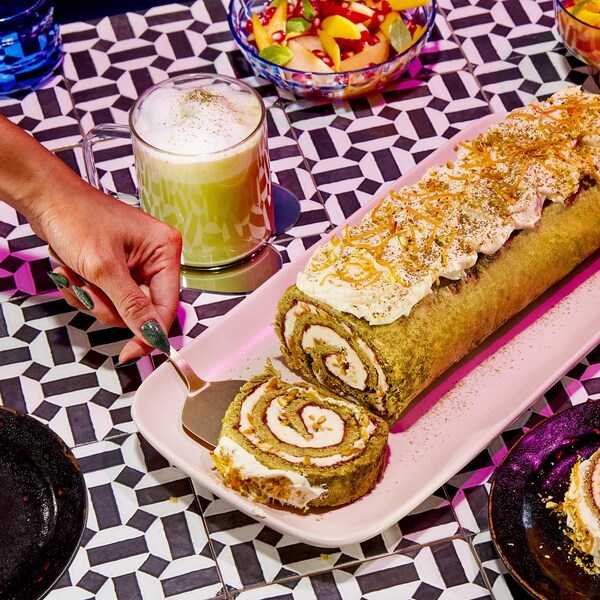 Une bûche au matcha en train de se faire découper en morceaux.
