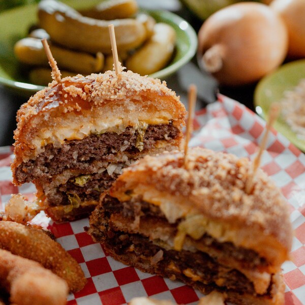 Un burger de deux boulettes coupé en deux.