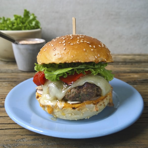 Un burger de veau dans une assiette bleu. 