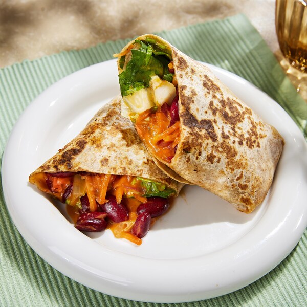 Un burrito minute aux haricots rouges coupé en deux dans une assiette.