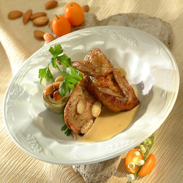 Cailles farcies, sautées, jus de persil aux amandes dans un bol assiette.