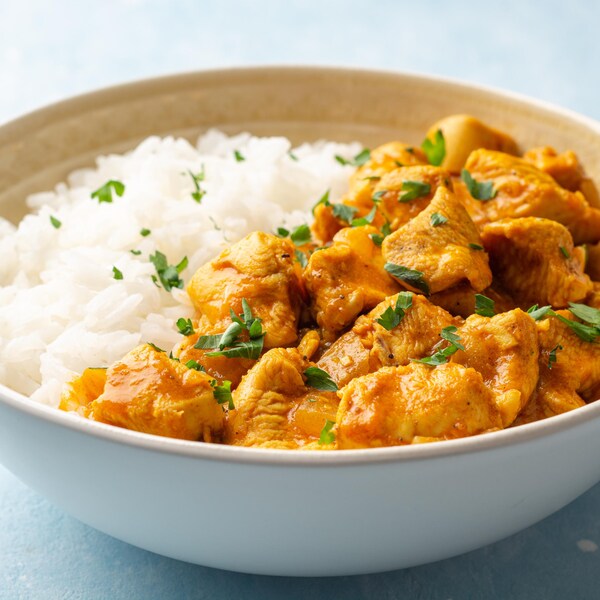 Un bol rempli de riz et de poulet au cari.