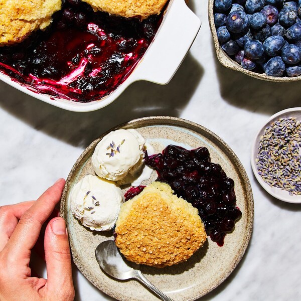 Un cobbler aux bleuets et à la lavande dans une assiette avec deux boules de crème glacée.