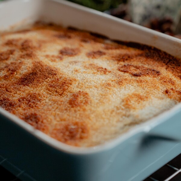 Un grand plat sortant du four rempli d'endives gratinées.