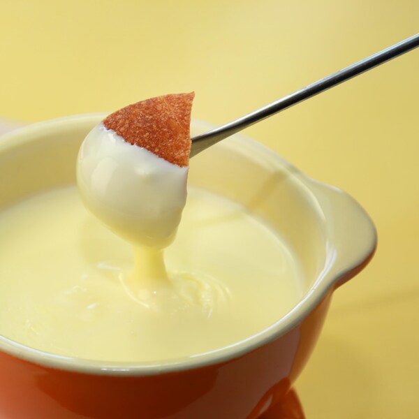 Un morceau de pain trempé dans du fromage fondu.