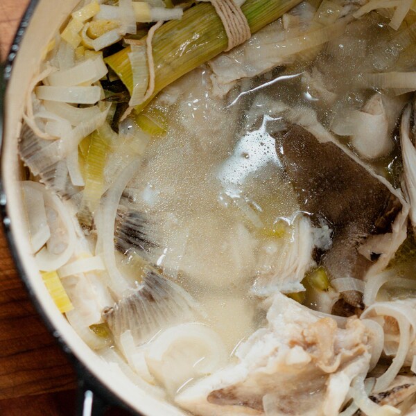 Un plat contenant du fumet de poisson et un autre bol en verre.