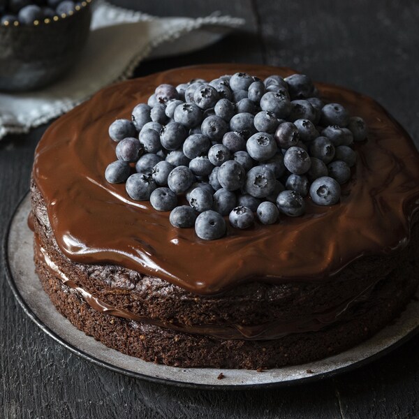 Un gâteau au chocolat sans gluten recouvert de bleuets.