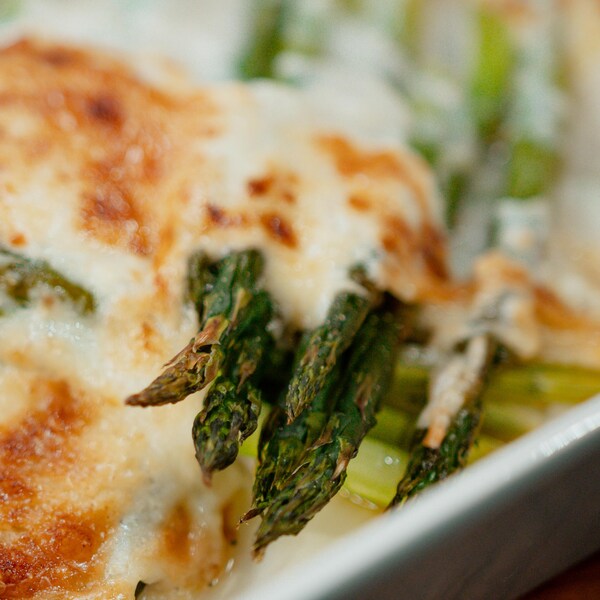 Des asperges recouvertes de fromage cheddar fondu.