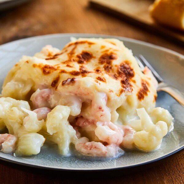 Un morceau de gratin de chou-fleur aux crevettes nordiques dans une assiette. 