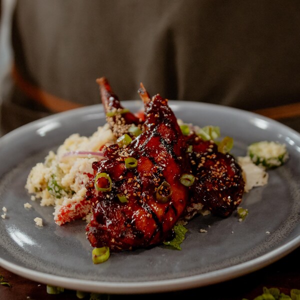 Des morceaux de lapin laqué servis avec une salade de couscous.