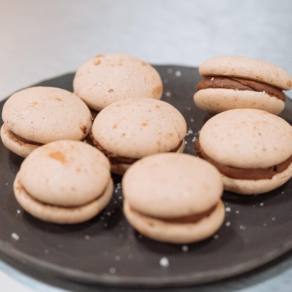 Des macarons à la ganache chocolat dans une assiette.