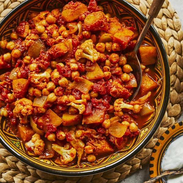 Sur une table, un grand bol contenant le mijoté et un bol de couscous, de persil et de vinaigrette. 
