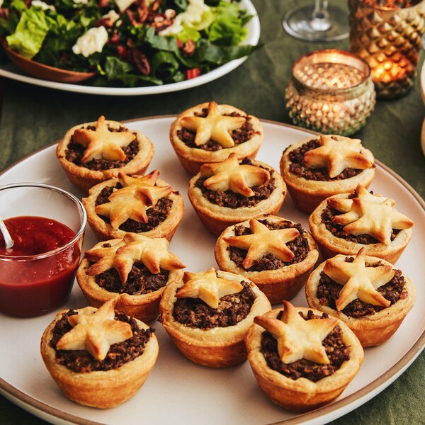 Sur une table, est déposé une grande assiette contenant quelques mini-tourtières. 