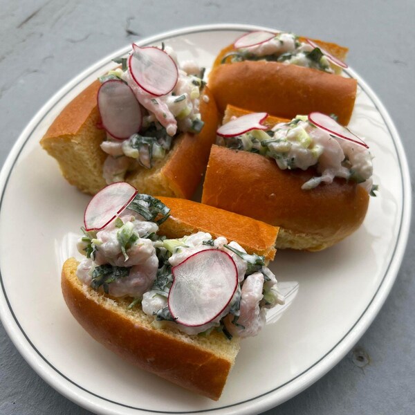 Des petits sandwichs aux crevettes nordiques dans une assiette.