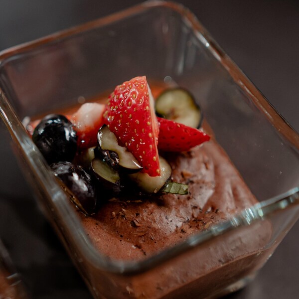 Une mousse au chocolat végétalienne recouverte de quelques fruits.