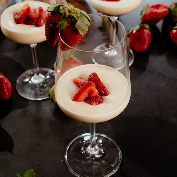 Une mousse à l'érable et au mascarpone servie dans un verre de vin avec des fraises.