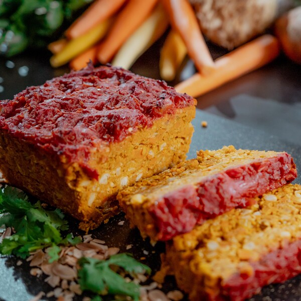 Deux tranches de pain de « viande » végétalien sur une planche à découper.