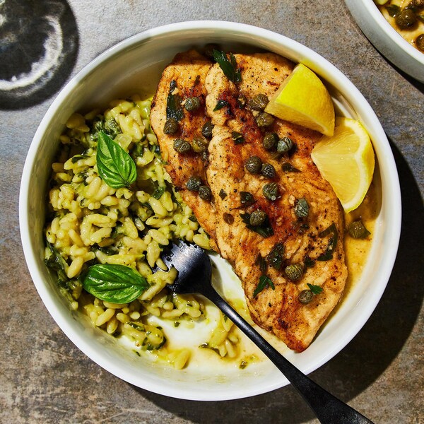 Un bol rempli de picatta de poulet et orzotto aux épinards.