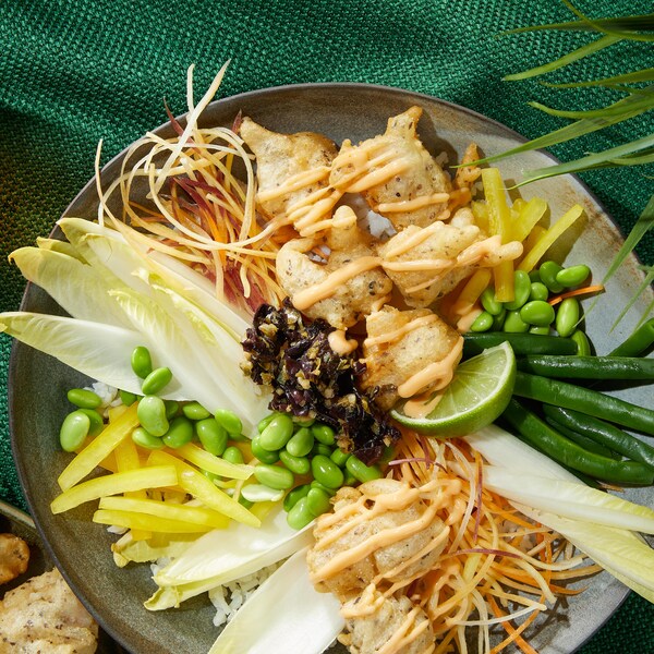 Un bol de poké aux crevettes avec des légumes.