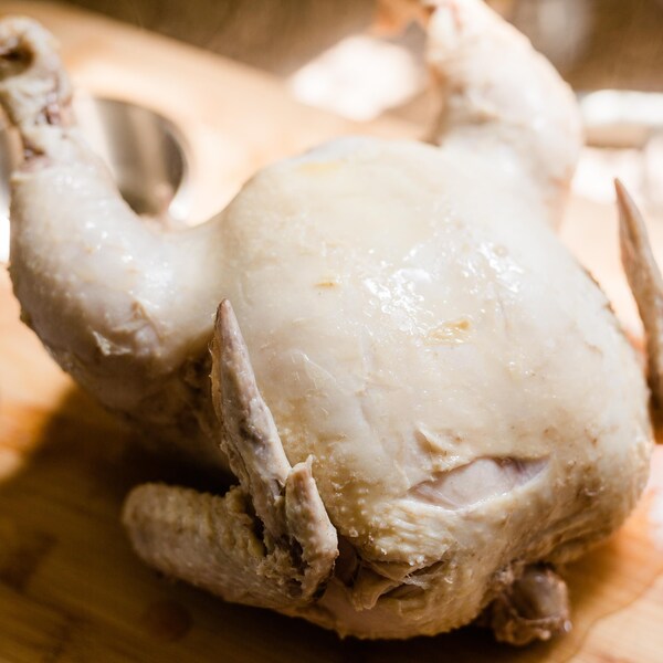 Un poulet poché sur une planche à découper.