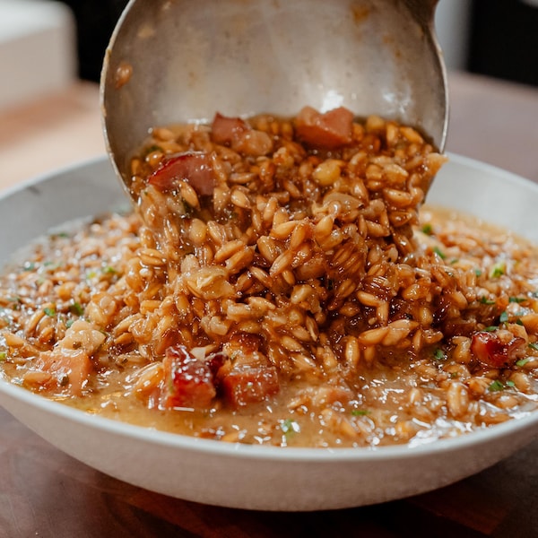 Une louche de risotto d'épeautre versée dans un bol de service.  