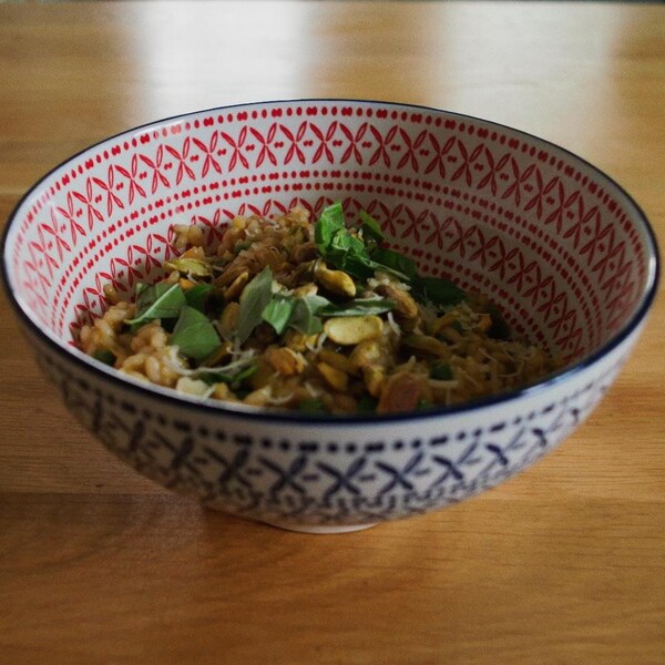 Un bol de risotto, du basilic et des pistaches.