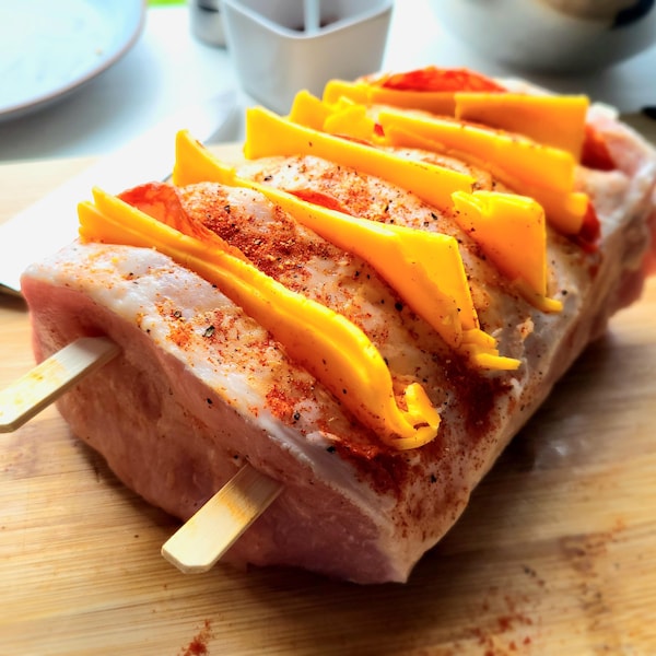 Un rôti de porc avec des tranches de cheddar et de chorizo dedans.