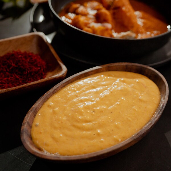 Un bol de sauce jaune et un bol d'épices à côté.