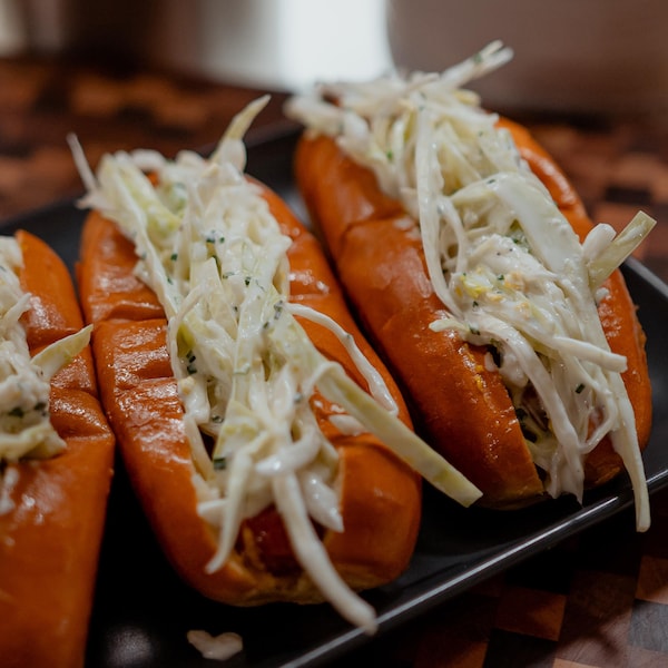 Quatre hot-dogs garnis de salade de chou crémeuse.