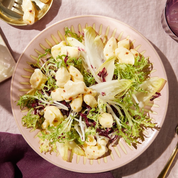Du fromage en grains sur une salade composée de laitue niçoise d'endives et de radicchio.