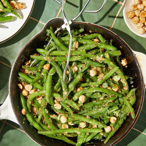 Salade de haricots verts, moutarde de Meaux et noisettes dans un grand bol.