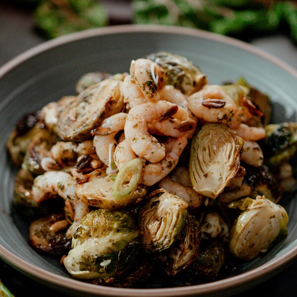 Une salade tiède de choux de Bruxelles et crevettes dans un large bol. 