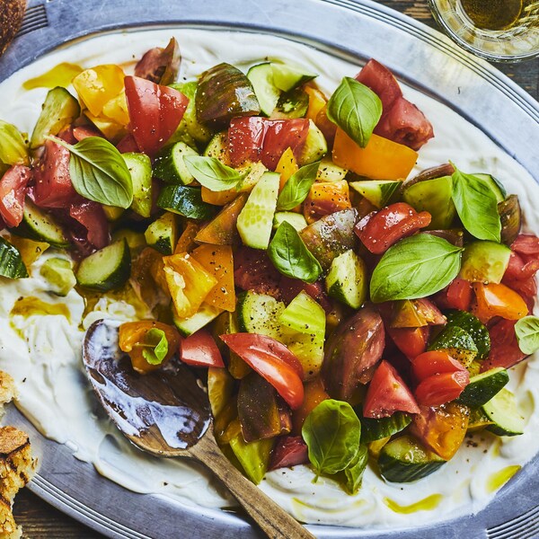 Salade de tomates à la ricotta fouettée dans une grande assiette de service.