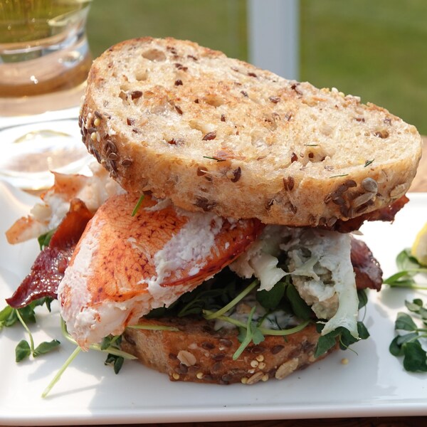 Un sandwich BLT au homard dans une assiette.